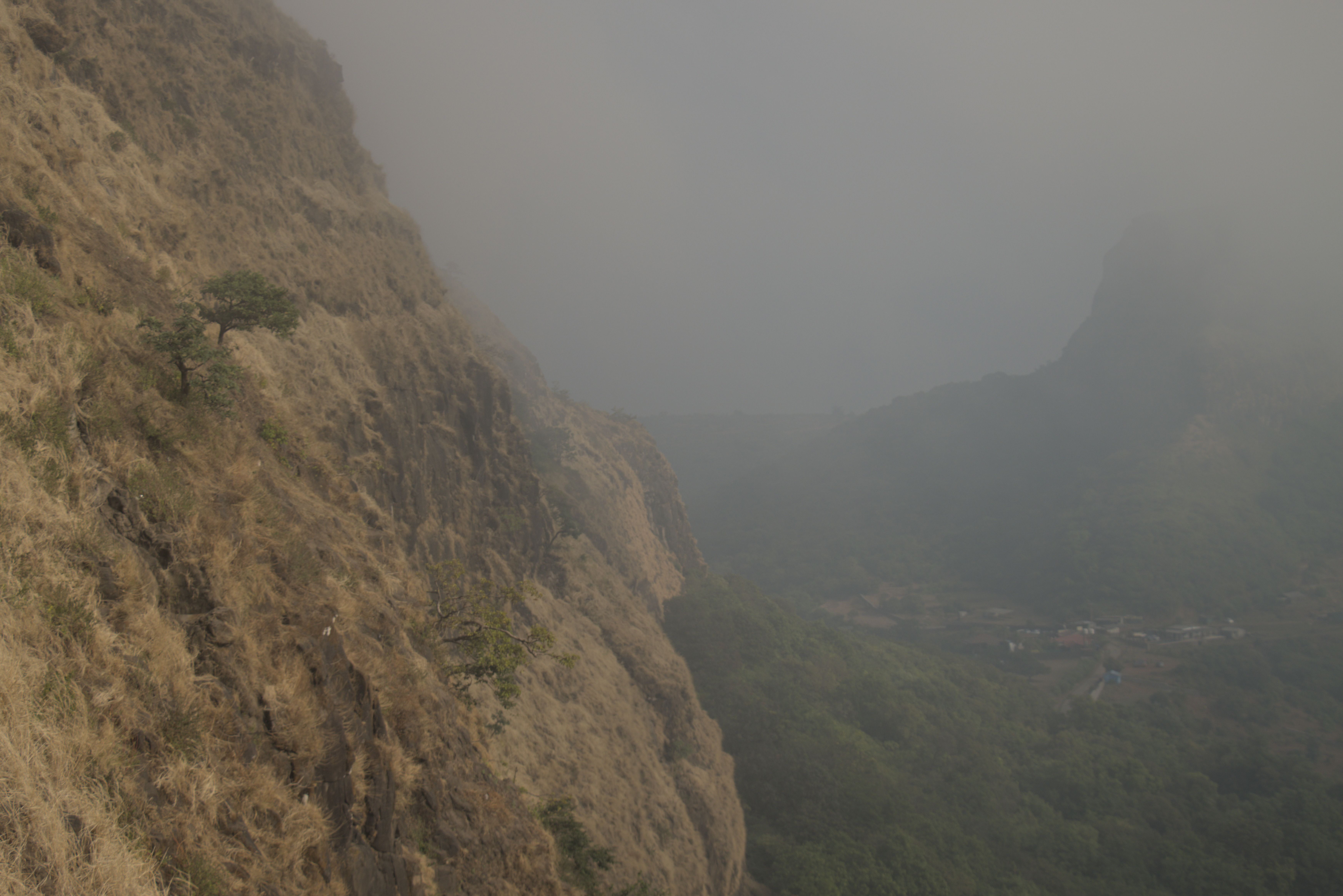 Looking down into the valley with Visapur Fort obscured by the fog in the top right.